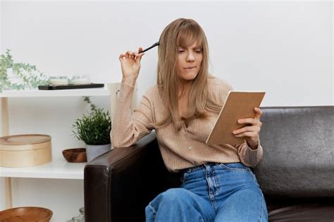Une étudiante blonde pensive et confuse avec un carnet de copie regarde de côté ne peut pas