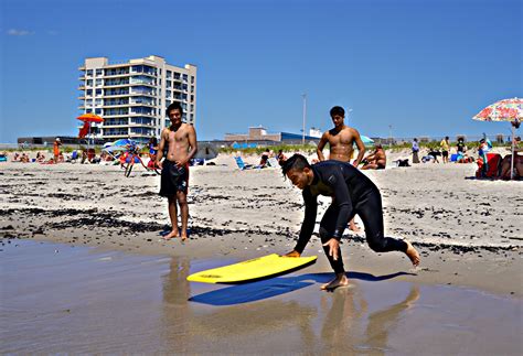Beachgoers test the waters at Rockaway Beach as pandemic life presses