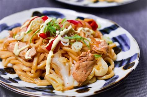 Two Plates With Noodles Meat And Vegetables On Them