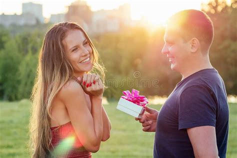 Lover Husband Gives A Gift Box To Embarrassed Attractive Beautiful Blonde Long Hair Wife In Love