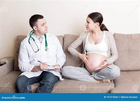 Male Doctor Is Writing Down Complaints Of Pregnant Woman Into A