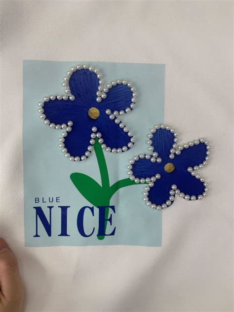 Two Blue Flowers On A White Background With The Words Nice Written In