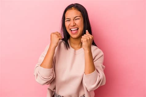 Jovem mulher latina isolada no fundo rosa torcendo despreocupada e animada Conceito de vitória