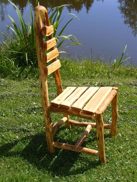 A Wooden Chair Sitting On Top Of A Lush Green Field Next To A Body Of Water