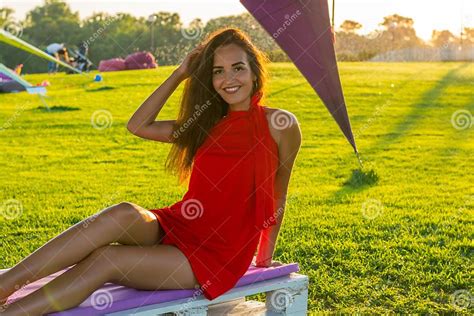 Beautiful Young Brunette Woman With Long Hair In A Red Dress Sit Stock