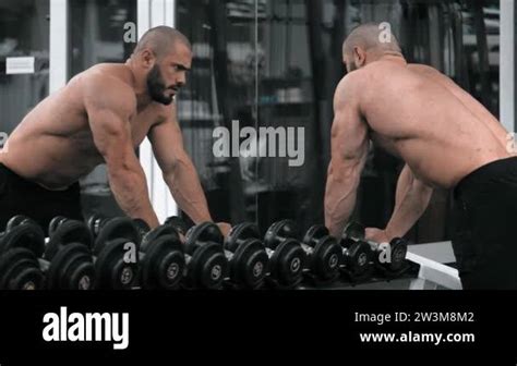 Male Bodybuilder Lifting Heavy Dumbbells At Gym Muscular Man In Naked Torso Resting Between