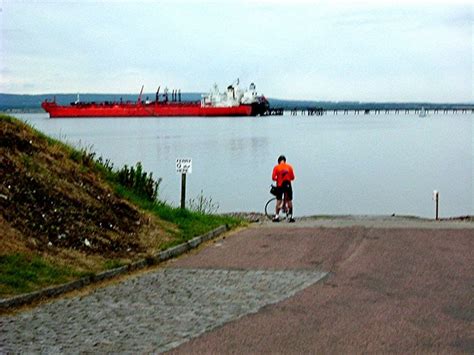 Cyclist checking tide tables at Cromarty pier Photo | UK Beach Guide