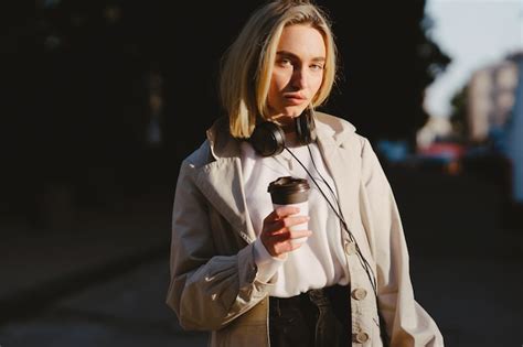 Blonde Se Promène Dans La Ville D été Avec Une Tasse De Café Photo Gratuite