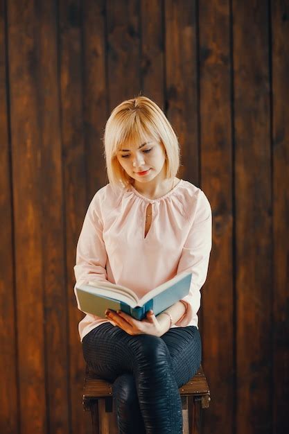 Fille Blonde Assise Sur Une Chaise Photo Gratuite