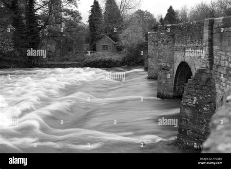 River Water Rushing Under The Arches Of An Old Stone Bridge Stock Photo