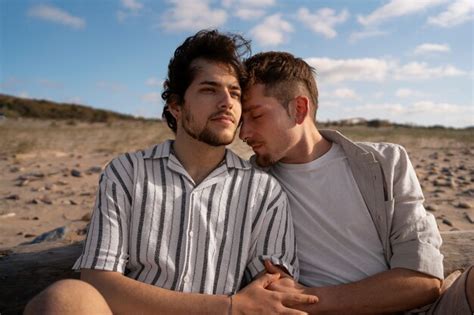 Casal gay de tiro médio na praia Foto Grátis
