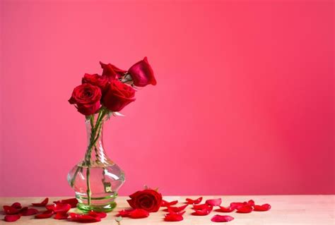 Premium Photo Red Roses In Glass Vase On Red Background