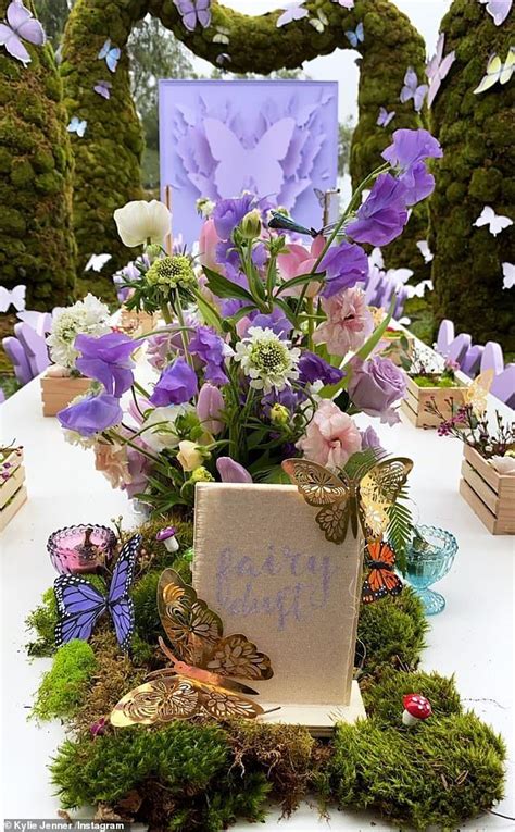 A Table Topped With Lots Of Purple Flowers And Butterflies Next To A