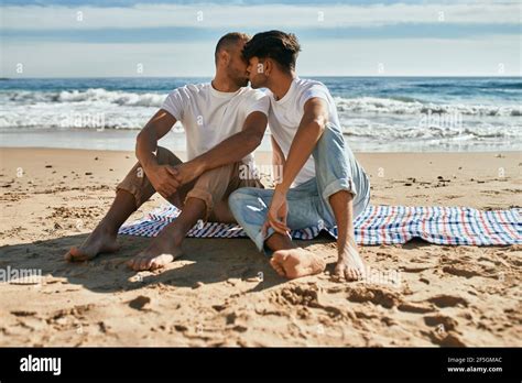 Un Jeune Couple Gay S Embrasse Assis La Plage Photo Stock Alamy