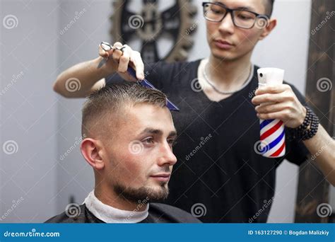 Kazakh Barber Gives the Client a Short Haircut with a Trimmer, a Man ...