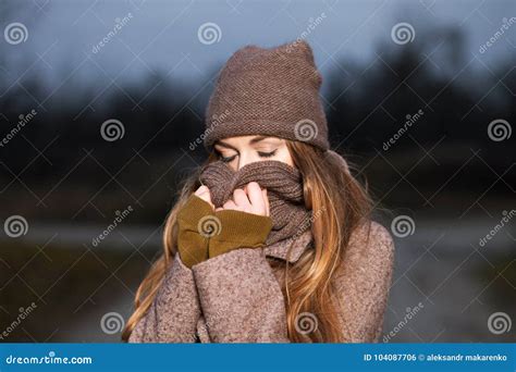 Girl In A Knitted Hat And Scarf Freezes In The Evening In The Autumn On