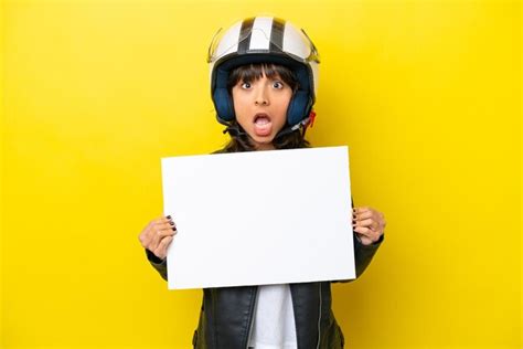 Jovem Mulher Latina Um Capacete De Moto Isolado Em Fundo Amarelo Segurando Um Cartaz Vazio