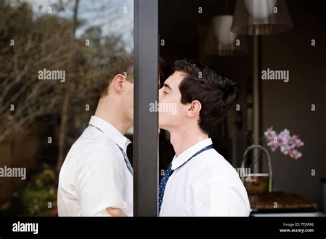 Vue latérale du couple gay s embrasser tout en se tenant à la porte Photo Stock Alamy