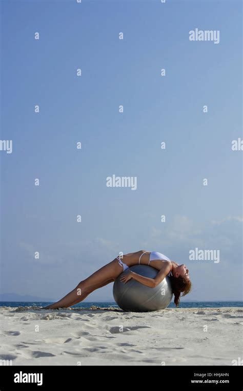 Frau Im Bikini Auf Riesigen Ball Am Strand Liegend Stockfotografie Alamy