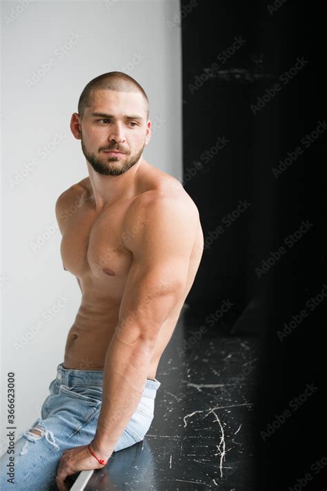Portrait Of A Man With A Beard A Man With A Naked Athletic Torso Poses In A Photo Studio On A