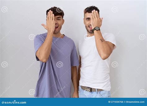 Homosexual Gay Couple Standing Over White Background Covering One Eye With Hand Confident Smile