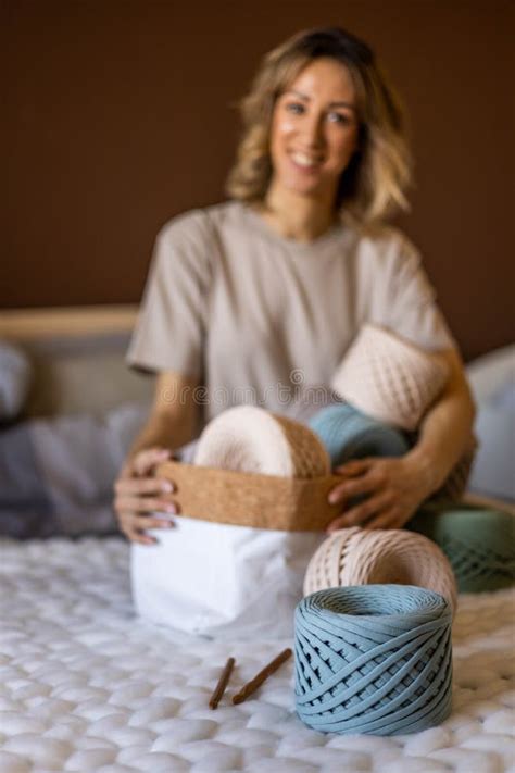 Portrait Smiling Blonde Woman Design Holding Pile Of Multicolored Hank Reel Ribbon Yarn Stock