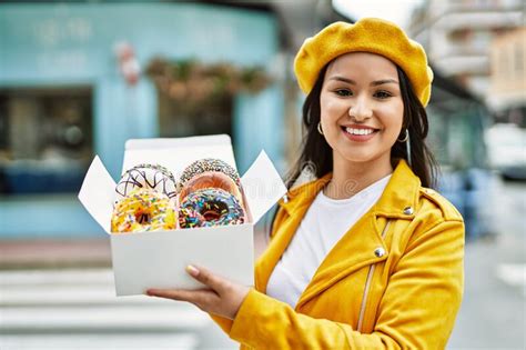 Jovencita Latina Sonriendo Feliz Caja De Espera Con Coloridas Donuts En La Ciudad Foto De