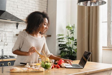 Online cooking tutorial. African young woman teenage girl using laptop ...