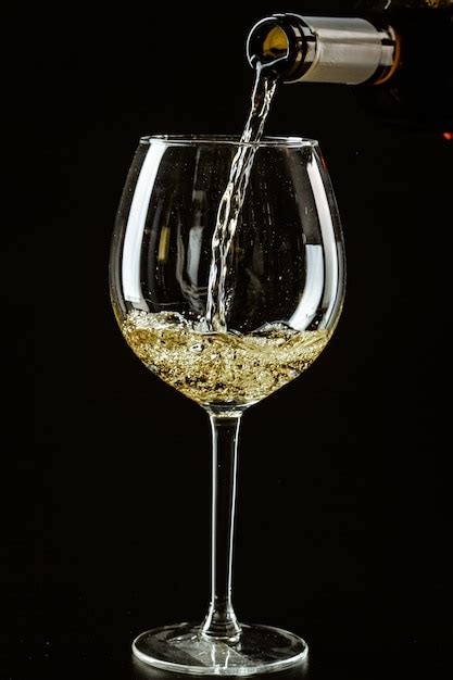 Premium Photo White Wine Being Poured In A Wine Glass