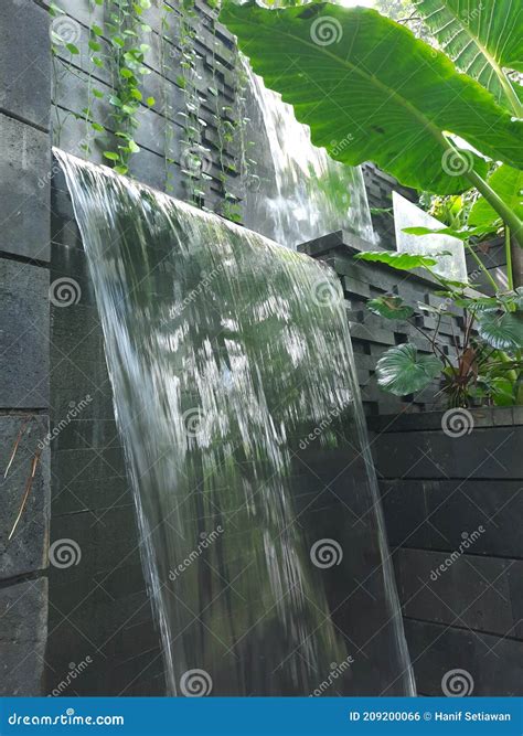 A Waterfall in Front of a Stonewall with Smooth but Fast Flowing Water