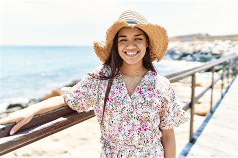 Jovencita Latina Sonriendo Feliz Usando Sombrero De Verano En La Playa Imagen De Archivo