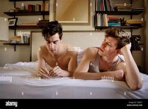 Gay Couple Relaxing On Bed At Home Stock Photo Alamy