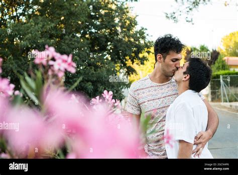 Jeune Couple Gay Amoureux Embrassant Dans La Nature Avec Des Fleurs En Premier Plan Deux Jeunes