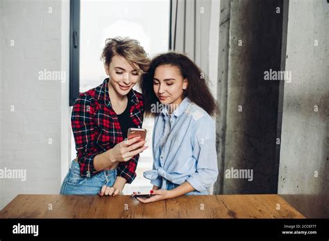 Schöne blonde und schwarzhaarige Frauen sind loking für wi Fi Nahaufnahme internet