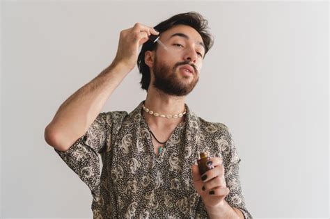 Joven Latino Queer Gay Aplicando Aceites En La Cara Con Un Cuentagotas