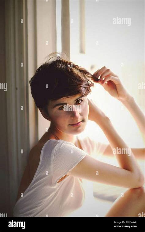 Pensive Portrait Of A Beautiful Short Haired Brunette Girl Wearing A Simple White Vest Top