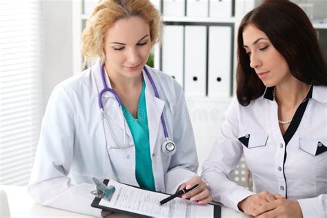 Blonde Female Doctor And Patient Talking In Hospital Office Health Care And Client Service In