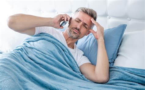 Premium Photo Confused Mature Man In Bed Speaking On Phone