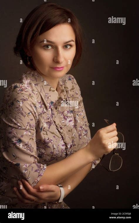 Studio Portrait Of A Brunette With Short Hair In A Dress With A Floral Pattern On A Black