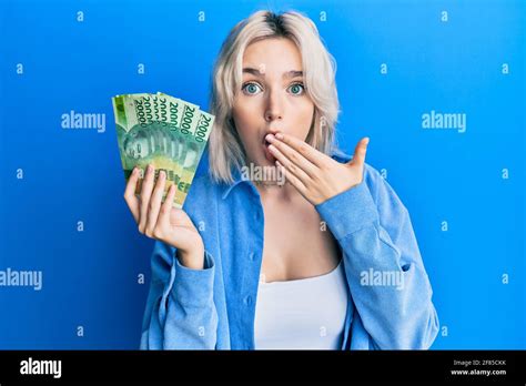 Jeune Fille Blonde Portant Des Billets De Roupie Indon Siens Couvrant La Bouche Avec La Main