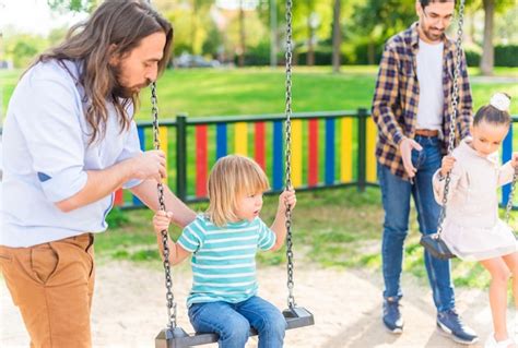 Una Joven Pareja Gay Jugando Con Sus Hijos En El Columpio Foto Premium