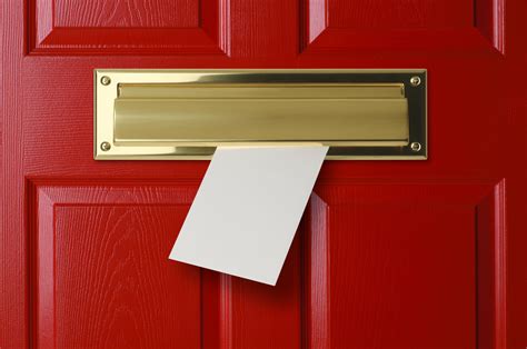 Letter Sliding Through Brass Mail Slot On A Red Door Uk