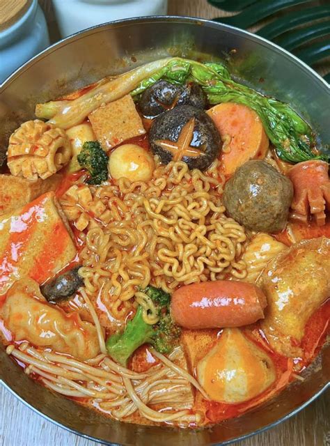 A Bowl Filled With Noodles Meats And Veggies On Top Of A Wooden Table