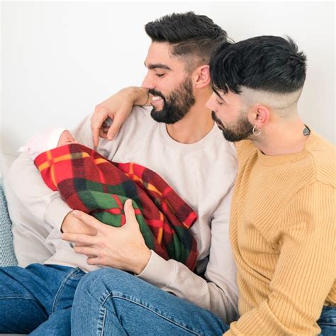 Heureux Couple Gay En Regardant Leur Bébé Enveloppé Dans Une Couverture Photo Gratuite