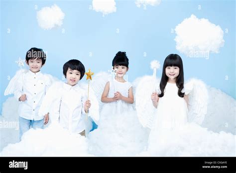 four kids with looks of angels on the clouds Stock Photo - Alamy