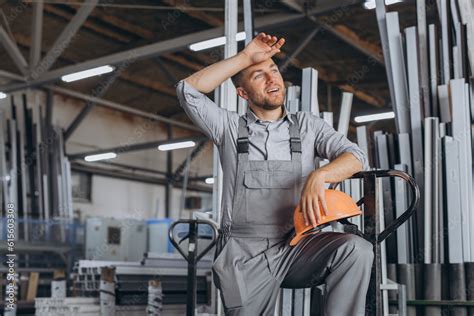 Portrait Of Happy Worker In Orange Hard Hat And Overalls Holding