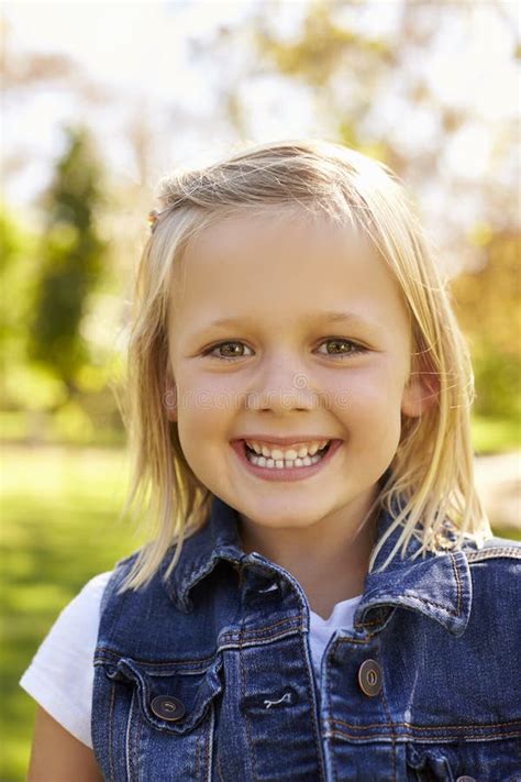 Five Year Old Blonde Girl In Park Smiles To Camera Vertical Stock Photo Image Of Person