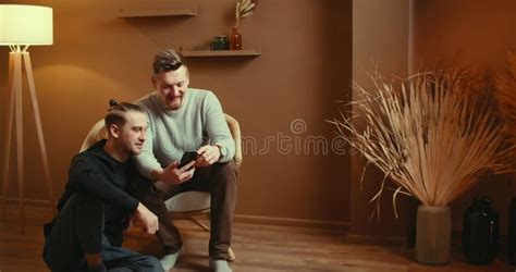 Cute Male Gay Couple Spend Time Sitting Chair Floor Use Smartphone Stock Footage Video Of