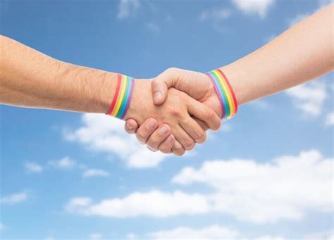 Premium Photo Hands With Gay Pride Wristbands Make Handshake