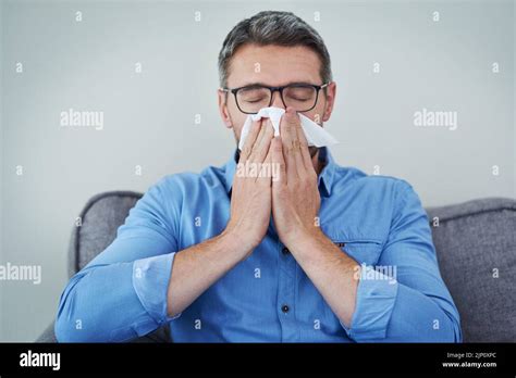 The Season Of Sneezes Is Here A Mature Man Blowing His Nose Stock Photo Alamy